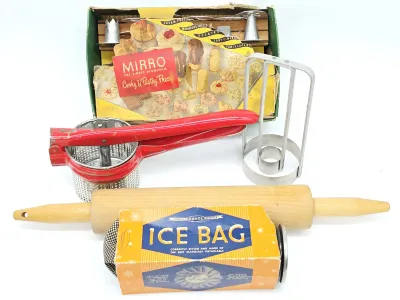 Vintage kitchenware collection including a Mirro Cooky & Pastry Press in its original box, a red metal potato ricer, a wooden rolling...