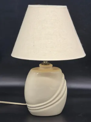 Vintage 1980s ceramic table lamp in a cream glaze with sculpted swirl details, complete with a beige fabric shade.