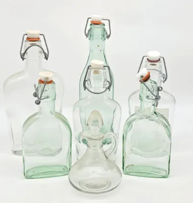 Collection of vintage glass bottles, including five swing-top bottles in clear and light green glass, and one small clear glass cruet...