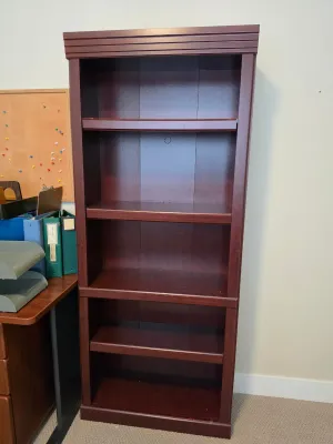 Tall cherry-finished wooden bookcase featuring five spacious shelves and a decorative crown molding top.