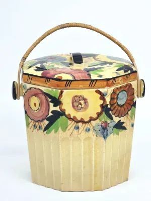 Vintage hand-painted ceramic biscuit barrel with a wicker handle, featuring a colorful floral design and a crazed glaze finish.