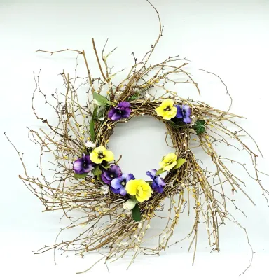 Rustic grapevine wreath adorned with faux purple and yellow pansies, green foliage, and delicate white accent flowers.