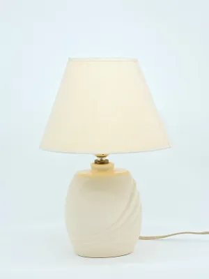 Vintage 1980s ceramic table lamp in a soft cream color, featuring a textured swirl design on the base and a matching tapered fabric shade.