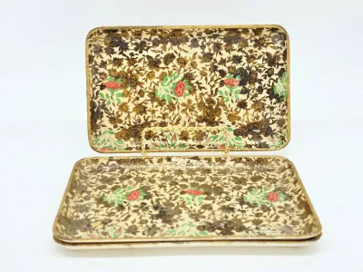 Vintage Florentine-style wooden trays featuring a dense floral pattern with red roses and gold accents, displayed on a wire stand.