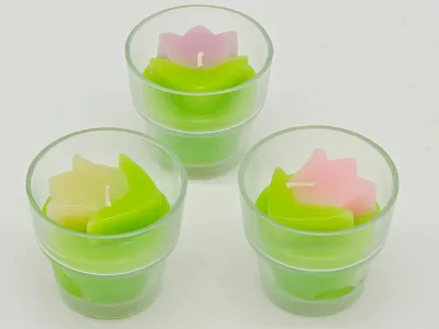 Set of three unused tulip-shaped votive candles in clear glass holders, featuring green bases with pink and yellow flower tops.