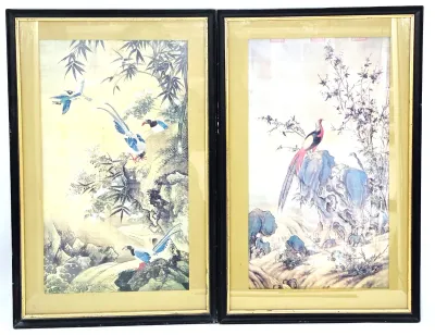 Pair of vintage framed Asian art prints depicting birds in natural landscapes, housed in black frames with gold-toned mats.