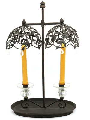 Vintage-style double candle holder in dark brown metal, featuring leaf-patterned dome shades with hanging glass crystals and clear glass...