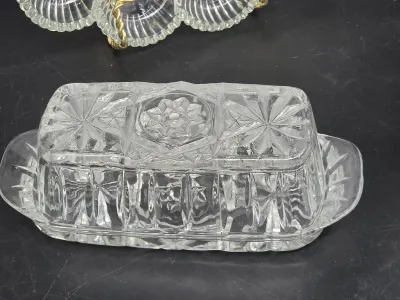 Vintage pressed glass butter dish with lid, featuring a starburst and geometric pattern.