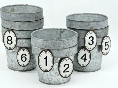 Set of rustic galvanized metal planter buckets, stacked and adorned with numbered oval tags from 1 to 8.