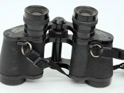 Vintage Hartmann Wetzlar 8x30 binoculars, made in Germany, featuring a textured black body and an attached neck strap.