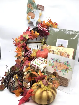 Assortment of Thanksgiving and autumn-themed decorations, including a pinecone turkey, faux pumpkins, a fall leaf wreath, a gnome welcome...