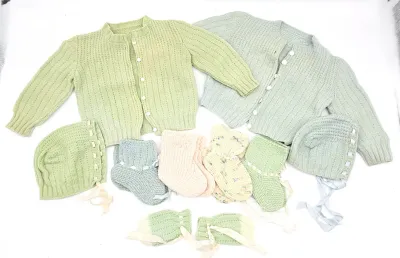Vintage hand-knitted baby clothing set, including two cardigans, matching bonnets, booties, and mittens in pastel green, blue, pink, and...