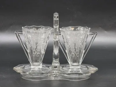 Depression-era clear glass cream and sugar set with matching handled tray, featuring an intricate etched floral pattern.