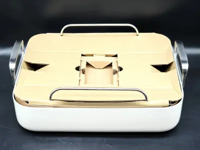 White rectangular roasting pan with chrome handles, unused in its original cardboard packaging insert.