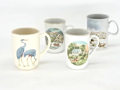 Set of four vintage ceramic mugs, including two Currier & Ives seasonal designs, one featuring blue herons, and one with a pastoral...
