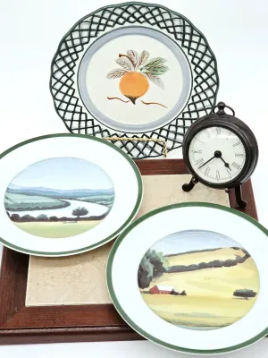 Collection of decorative items including three hand-painted ceramic plates with landscape and fruit motifs, a small vintage-style metal...