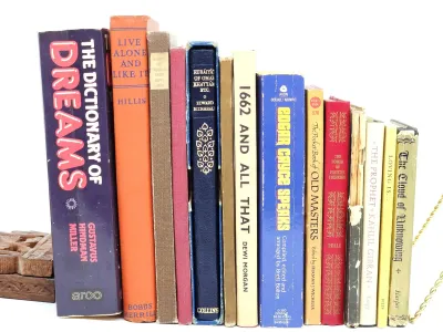 Collection of vintage books including "The Dictionary of Dreams" and "Edgar Cayce Speaks," showing moderate shelf...