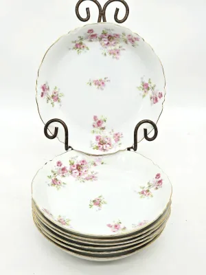 Set of Haviland Limoges porcelain soup bowls featuring a delicate pink rose pattern with gold-rimmed scalloped edges.