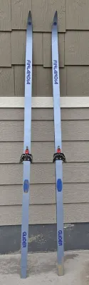 Vintage Finlandia Glider cross-country skis with bindings, showing some wear from use.