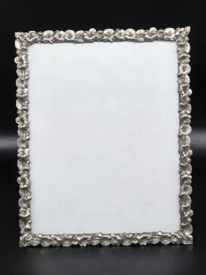 Vintage pewter or silver-tone metal picture frame featuring an ornate, embossed floral and leaf border.