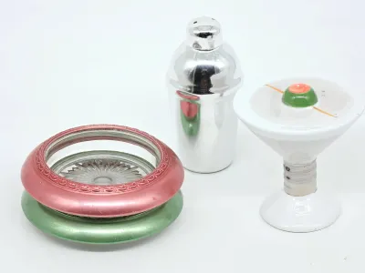 Vintage barware-themed salt and pepper shakers, featuring a miniature chrome cocktail shaker and a ceramic martini glass with an olive,...