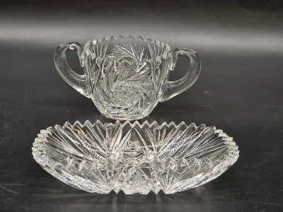 American Brilliant Period cut glass sugar bowl and matching oval dish, featuring intricate pinwheel and starburst patterns with saw-tooth...