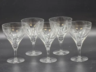 Set of five vintage crystal cocktail glasses featuring an elegant etched starburst and leaf pattern.