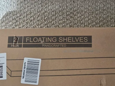 A boxed two-pack of handcrafted floating shelves, showing the cardboard packaging with barcodes.