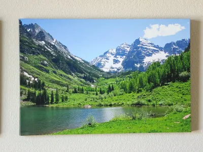 Large unframed canvas print depicting a scenic mountain landscape with a lake, green valley, and snow-capped peaks.