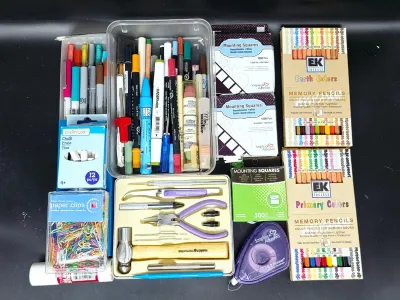 Assorted crafting and scrapbooking supplies, including EK Success memory pencils, mounting squares, a small tool kit, paper clips, and...