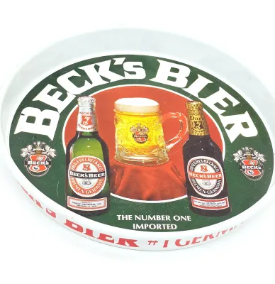 Vintage Beck's Bier metal bar tray featuring illustrations of beer bottles and a filled mug, showing some light wear and scratches.