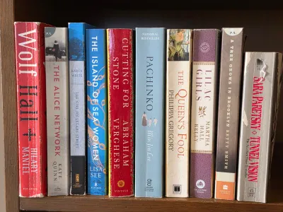 Collection of ten paperback fiction novels, including titles such as Wolf Hall, Pachinko, and A Tree Grows in Brooklyn, showing some...