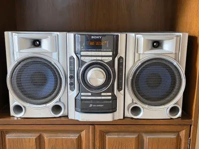 Sony MHC-EC55 mini hi-fi component system featuring a 3-disc CD changer, AM/FM tuner, and two matching silver speakers, circa 2000s.