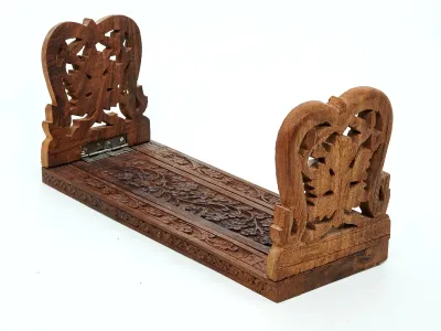 Hand-carved wooden sliding bookrack featuring intricate floral and leaf motifs with folding end supports.