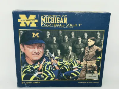 "University of Michigan Football Vault: The History of the Wolverines" book by Jerry Green, featuring a slipcase with historic...