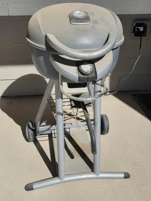Char-Broil Patio Bistro electric grill on a wheeled stand, showing some dust and wear from outdoor storage.