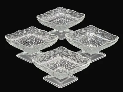 Set of four vintage clear pressed glass footed dessert bowls featuring a floral and diamond-cut pattern.