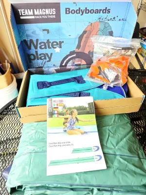 Team Magnus Devilfish Slip and Slide set, including the original box, inflatable bodyboards, stakes, and instruction manual.