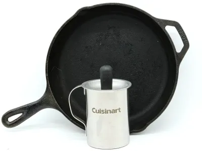 Lodge cast iron skillet paired with a stainless steel Cuisinart frothing pitcher.
