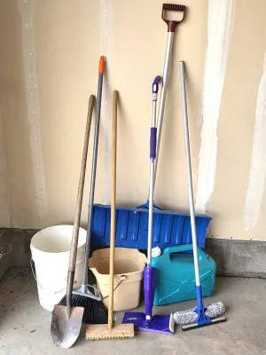 Assortment of household cleaning and yard tools, including a shovel, broom, push broom, Swiffer mop, window squeegee, snow shovel,...