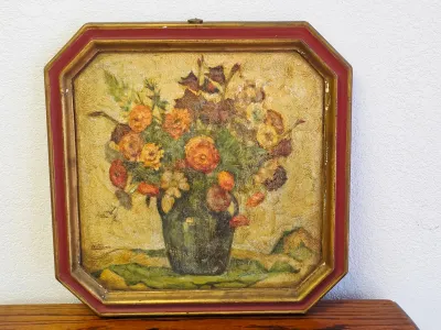 Vintage oil painting depicting a floral still life in a green vase, housed in an octagonal gold and red painted wooden frame.