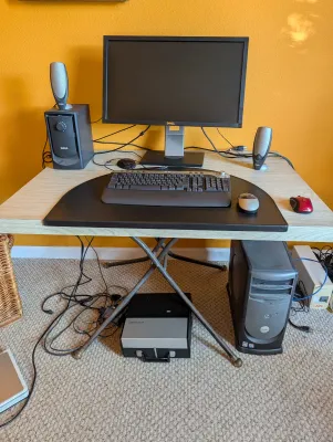 Vintage Dell desktop computer setup including a flat-screen monitor, tower, keyboard, mice, and speakers, arranged on a light wood-look...