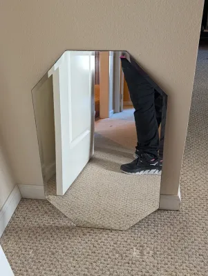 Frameless octagonal wall mirror with beveled edges.