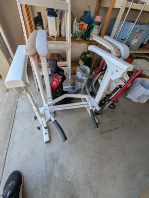 Lumex Stand Assist patient lift frame, showing some light wear from use, alongside medical walking boots in a garage setting.