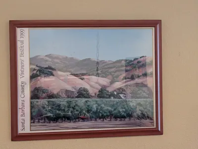 Framed 1999 Santa Barbara County Vintners' Festival poster featuring a scenic vineyard landscape illustration, housed in a...