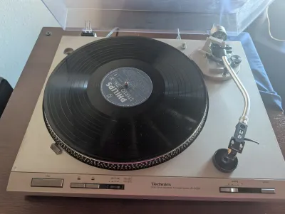 Technics SL-D202 direct drive automatic turntable system with a clear dust cover, shown with a Philips vinyl record on the platter.