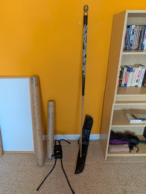 Two-piece pool cue featuring a black butt with a white dragon design and a brass joint, shown with its black carrying case, alongside...