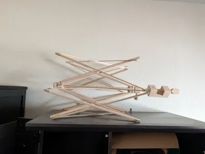 Wooden umbrella yarn swift with a table clamp, designed for winding skeins of yarn into balls.