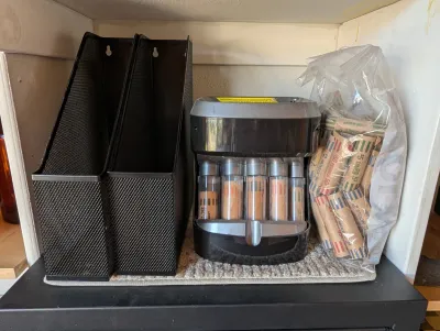 Royal Sovereign electric coin sorter with a bag of paper coin wrappers, flanked by two black mesh metal magazine holders.