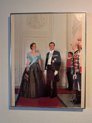 Framed color photograph depicting Queen Margrethe II and Prince Henrik of Denmark in formal attire, presented in a simple silver-toned...